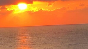 A sunset over a body of water with clouds reflecting the sunlight. - 3-person studio deck 15m2 facing Le Diamant (Le Diamant)
