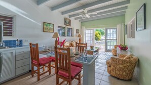 A spacious kitchen with a dining area, wooden furniture, and a view to the outside. - Oceanfront 2 Bedroom Premium Villa (Tortola)