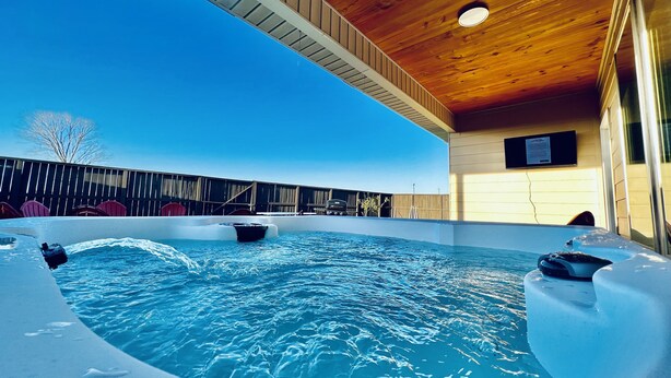 Una piscina interior con techo de madera y vista al cielo.
