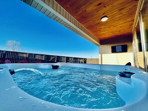 An indoor swimming pool with a wooden ceiling and a view of the sky.