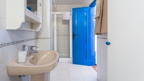 Ein Badezimmer mit Waschbecken, Spiegel und Dusche.