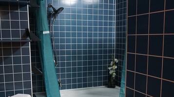 A bathroom with a bathtub, toilet, and shower.