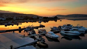A marina with boats docked at the pier during sunset.