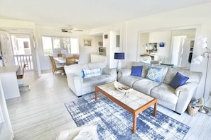 Relax in this inviting living space with a large sofa, armchair, and dining area.