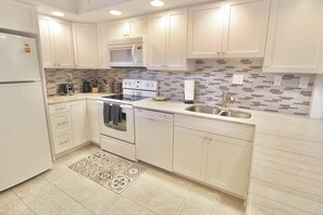 Enjoy cooking in this well-equipped kitchen with a microwave, stainless steel sink, and modern faucet.