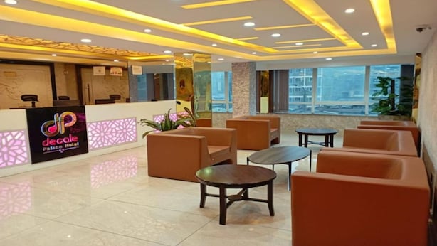 A hotel lobby with a reception desk, seating area, and large windows. - Decale Palace Hotel (Nairobi)