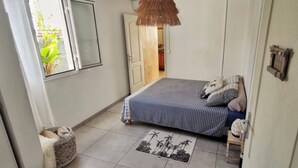 A bedroom with a bed, a window, a door, and a small rug. - Bleu Salé, magnificent waterfront villa (L'Étang-Salé)