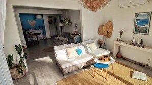 A living room with a sofa, a coffee table, and a dining area in the background. - Bleu Salé, magnificent waterfront villa (L'Étang-Salé)
