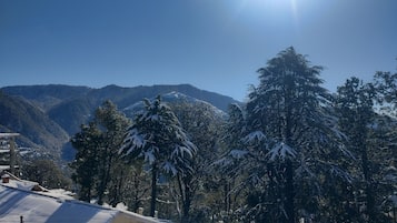 A snowy mountain landscape with a clear sky and a building with a snow-covered roof.