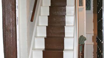 A wooden staircase with white risers leading to a landing.