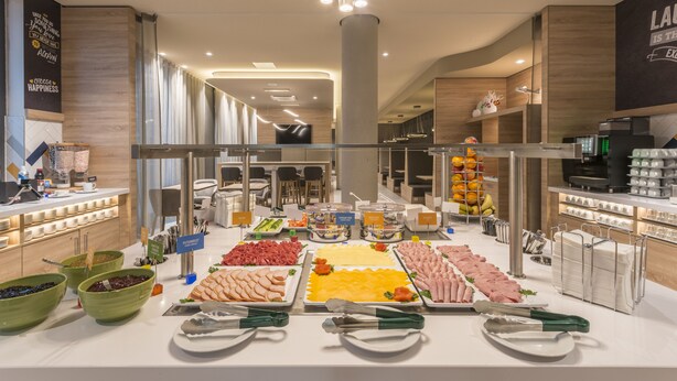 A buffet with various food items, including meats, cheeses, and fruits. - Hampton by Hilton Munich City North (Munich)