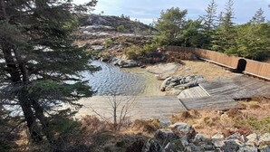 A wooden bridge over a rocky stream, surrounded by trees and a wooden walkway. - Vacation home on Bømlo perfect family vacation for hikers and cyclists (Rolvsnes)