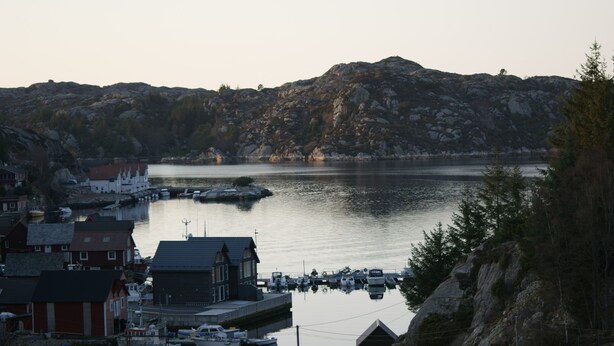 A harbor with boats docked, buildings, and a mountainous backdrop. - Vacation home on Bømlo perfect family vacation for hikers and cyclists (Rolvsnes)