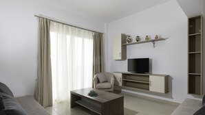 Ein modernes Wohnzimmer mit einer Couch, einem Couchtisch, einem Fernseher und einer Kommode mit Dekoration.