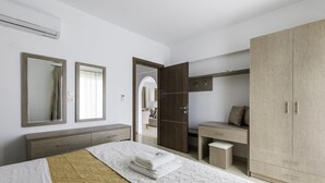 Un dormitorio moderno con una cama, un escritorio y un armario.