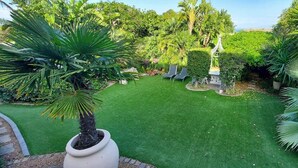 A well-maintained garden with a lawn, various plants, and a small decorative structure. - Roosboom Luxury Studio - With Sea View and Kitchen, Ideal for 2 Guests, Capetown (Cape Town)