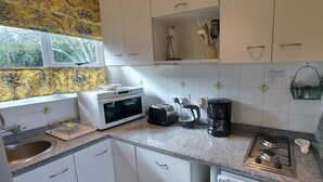 A kitchen with white cabinets, a microwave, toaster, coffee maker, and a gas stove. - Roosboom Luxury Studio - With Sea View and Kitchen, Ideal for 2 Guests, Capetown (Cape Town)