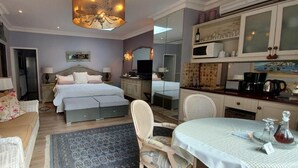 A hotel room with a bed, a sofa, a dining table, and a kitchen area. - Platinum Suite With Private Terrace! For 2 Guests - Roosboom Luxury Apartment (Cape Town)