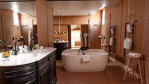 Un baño moderno con una bañera grande, un lavabo doble y una ducha a pie.