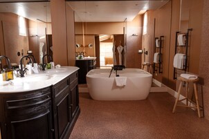 Un baño moderno con una bañera grande, un lavabo doble y una ducha a pie.
