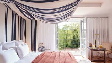 Un dormitorio con cama, balcón y una mesa con bebidas.