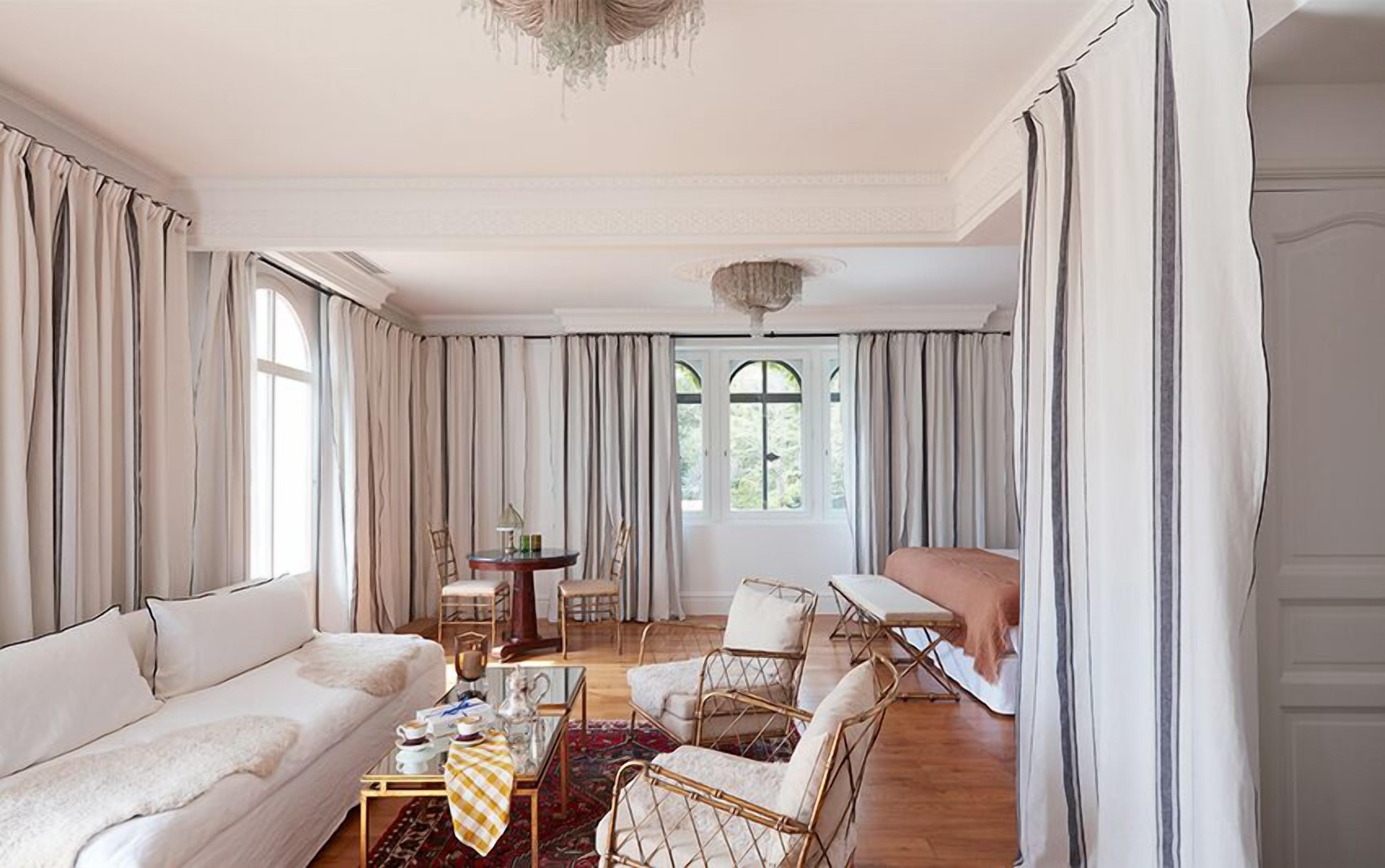 A spacious living room with a sofa, chairs, a coffee table, and a dining area with a table and chairs.