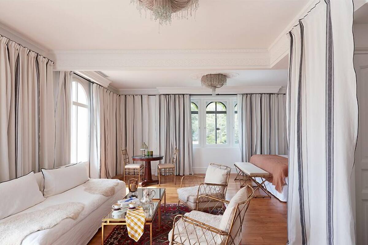A spacious living room with a sofa, chairs, a coffee table, and a dining area with a table and chairs.