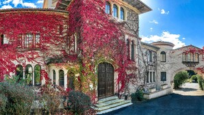 A historic building with a curved facade, arched windows, and a prominent entrance. - Brindos Lac & Château (Anglet)