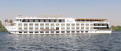 A large white river cruise ship with multiple decks and outdoor seating areas.
