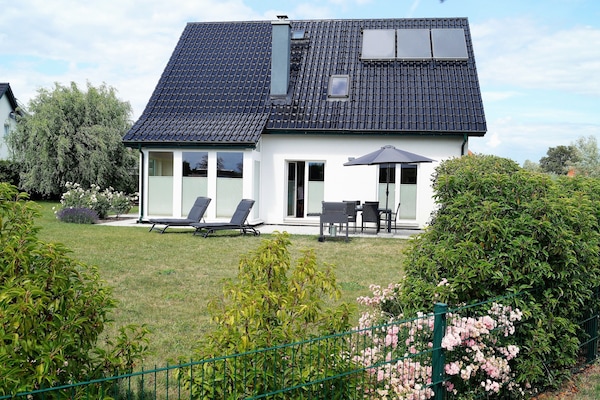 Haus mit Terrasse und großem Rasen-Grundstück