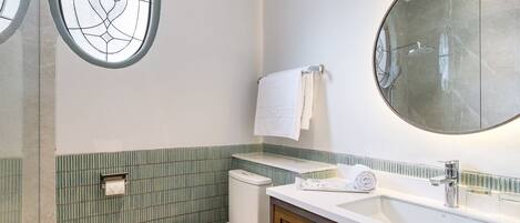 Un baño con inodoro, lavabo y espejo.