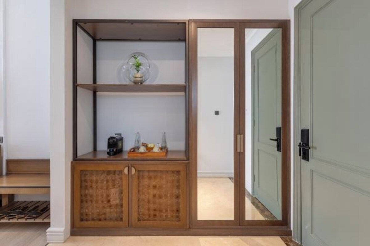 Een kamer met een houten kast, een glazen deur en een bank.