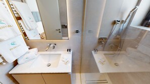 Un bagno moderno con due lavabi, uno specchio grande e un box doccia.