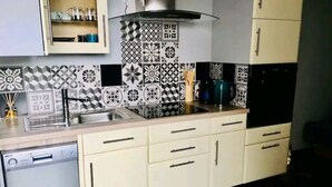 Una cucina con piastrelle decorate, una lavastoviglie e mobili.