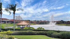 A gazebo, a fountain, and a lake with buildings in the background. - Encantada - 4 bed 3 bath lakefront corner house (Kissimmee)