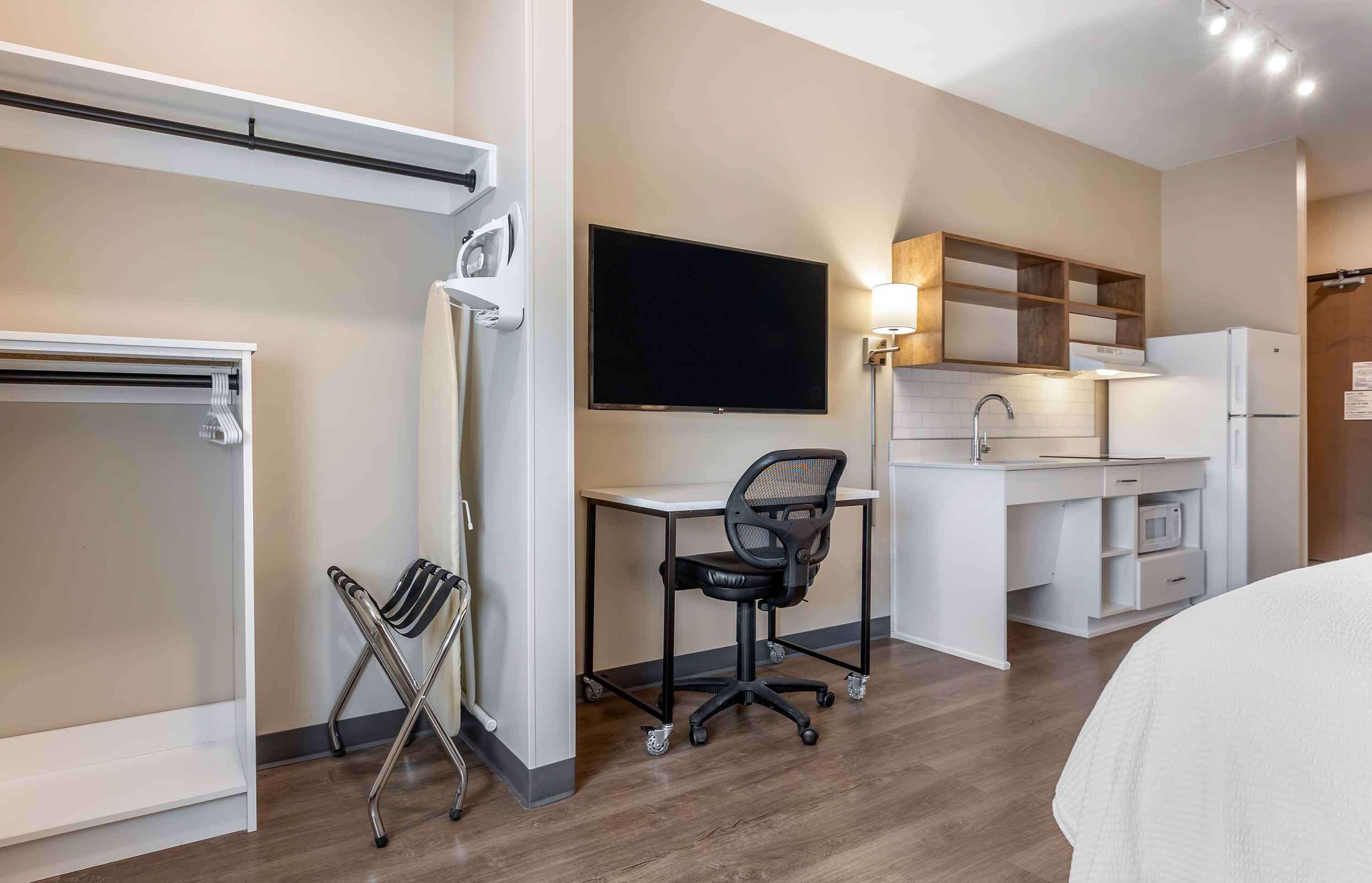 laptop workspace, iron/ironing board, bed sheets