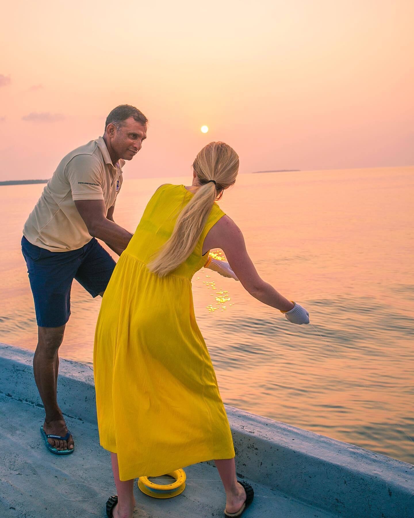Una pareja junto al agua al atardecer.