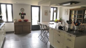 Een moderne keuken met een centraal eiland, een eethoek en uitzicht op het buiten.