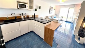 Een moderne keuken met witte kasten, een zwart aanrecht en een houten kookeiland.