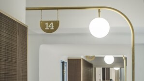 Un pasillo moderno con una escalera, un letrero con el número 14 y un letrero con el número 15.