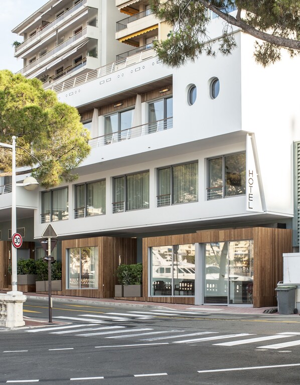 Un hôtel moderne à la façade blanche, doté de nombreux balcons et de grandes fenêtres.