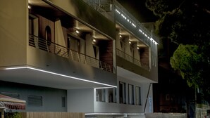 Un hotel moderno de dos pisos, con balcones y una entrada visible.