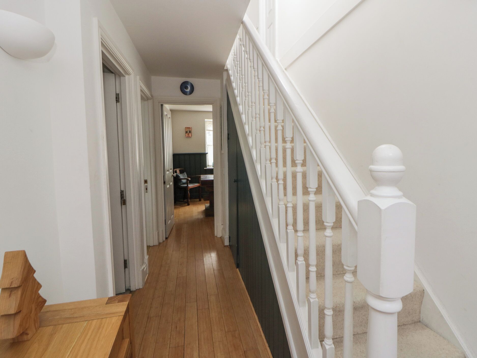 A wooden staircase with white balusters leading to a landing.