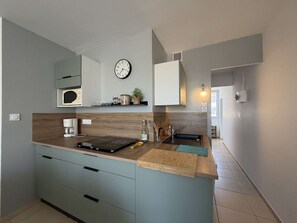 A modern kitchen with a built-in microwave, a clock, and a coffee maker.