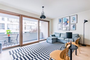 A modern living room with a sofa, chairs, a coffee table, and a large window. - Gelman's Getaway in Lisbon (Lisbon)