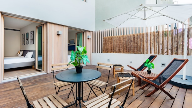 A modern outdoor patio with a round table, wooden chairs, and lounge chairs. - Gelman's Getaway in Lisbon (Lisbon)
