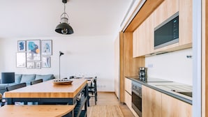 A modern kitchen with wooden cabinets, a built-in microwave, and a stainless steel range hood. - Gelman's Getaway in Lisbon (Lisbon)