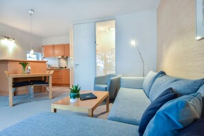 Una sala de estar moderna con un sofá, una mesa de centro y un comedor con una mesa y sillas.