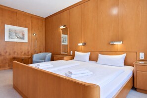 A hotel room with a large bed, two bedside tables, a chair, a desk, a mirror, and a framed picture on the wall. - House Ardenne 04 - only a few meters to the fine sandy Baltic Sea beach (Heringsdorf (Seebad))