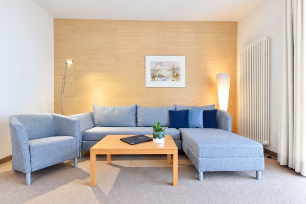 Una sala moderna con un sofá modular, una mesa de centro y una lámpara de pie.